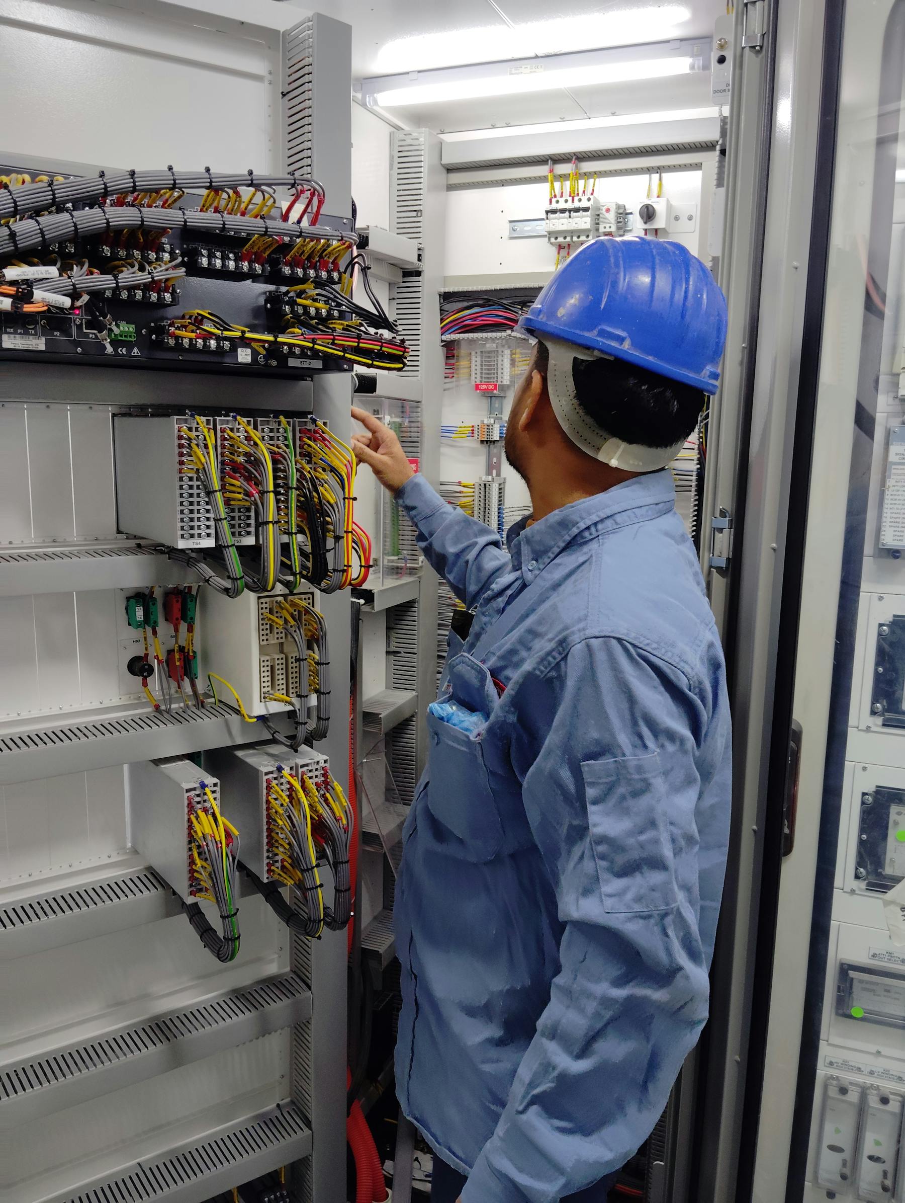 Electrical engineer inspecting an industrial control cabinet