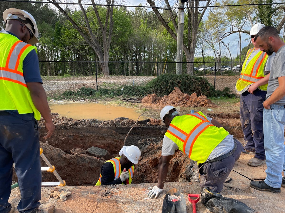 Utility crew inspecting an underground service trench